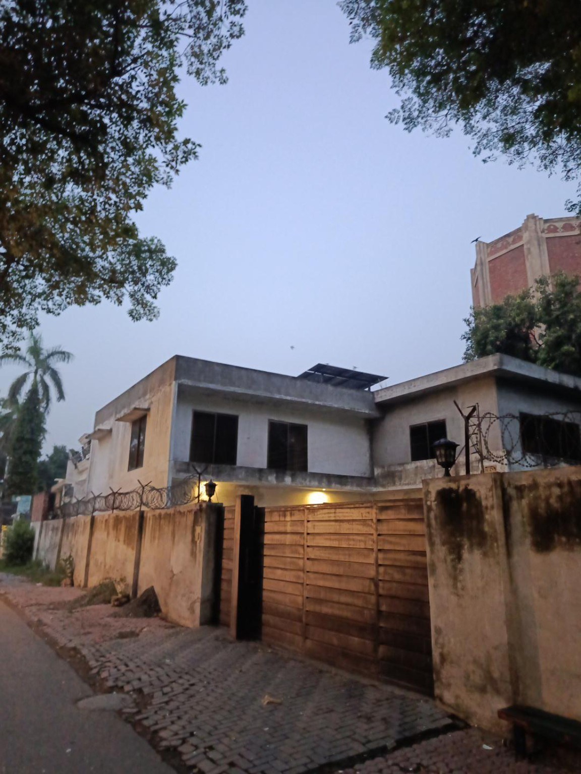 Low-rise home with rooftop solar panels and trees